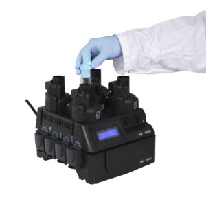 OGI3 Base unit powered on with a liquid control module connected to it. A hand is shown inserting a culture flask into reactor C